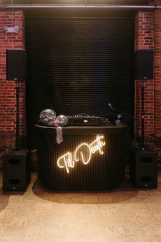 a hot tub with lights and speakers on the side in front of a brick wall