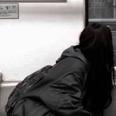 a woman sitting on a subway bench with her head down