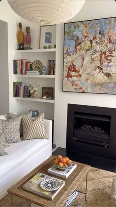 a living room filled with furniture and a fire place in front of a painting on the wall