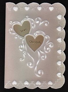 two hearts on a white doily with the word love