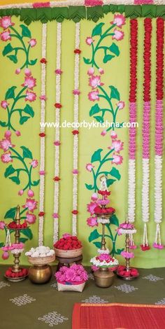 the table is decorated with pink flowers and white beads on it's side, along with other decorations