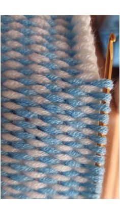 blue and white yarn with gold pins on it's end, next to a pair of scissors