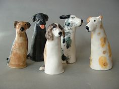 five ceramic dog figurines are lined up in a row