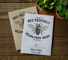 two bee - friendly wildflower seeds sitting on top of a wooden table next to a potted plant