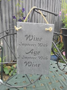 a slate sign that says wine improve with age