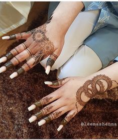 two hands with henna tattoos on them