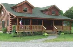 a log cabin with porches and an american flag