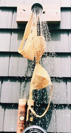 a shower head is sprinkled with water from a faucet on the side of a building