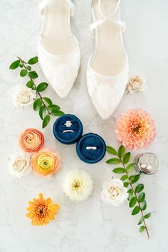 wedding shoes and boutonnieres laid out on a marble surface