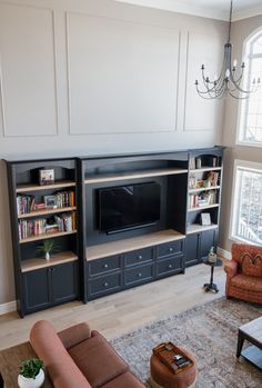 a living room filled with furniture and a flat screen tv on top of a wooden entertainment center