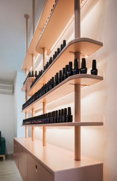 the shelves have many bottles on them and are lined up against the wall with lights