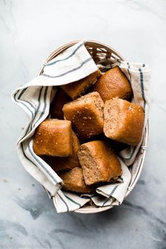 a basket filled with cut up bread on top of a marble countertop next to a towel