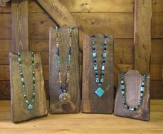 several necklaces are displayed on wooden boards