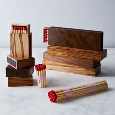 three matches are lined up next to each other on a marble countertop with wooden boxes holding matches