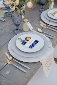 the table is set with white plates and silverware, napkins, and flowers