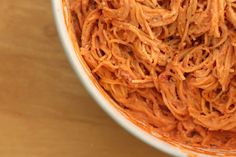 a bowl filled with spaghetti on top of a wooden table