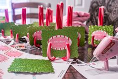 pink and green centerpieces are sitting on the table with red candles in them