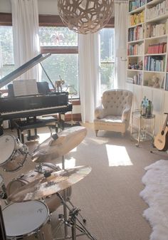 a living room filled with lots of furniture and a piano in front of a window