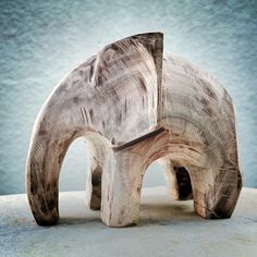 an elephant made out of wood sitting on top of a table