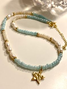 This beautiful necklace features freshwater Pearl beads and baby blue and cream seed beads. Finished with a dainty hammered gold star. Approximately 18 " length. Message me if you require a shorter length. Layer up with other necklaces or wear alone for a cute 90's vibe. JEWELLERY CARE GUIDE *Remove jewelry before bathing, showers and swimming *Keep jewelry away from humidity and water *Avoid contact with makeup, perfume, lotion and other chemicals.  *Remove before sleeping and any other exercis Small Beaded Necklace, Blue Seed Bead Necklace, Hessian Bags, Perfume Lotion, Baby Pearls, Hammered Gold, Fresh Water Pearl, Seed Bead Necklace, Unique Gifts For Her