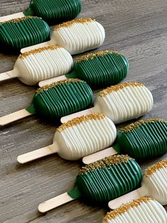 green and white pops with gold sprinkles on them sitting on a wooden table