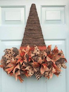 a burlocked wreath with orange and brown flowers is hanging on the front door