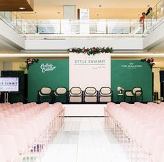 rows of pink chairs in front of a green and white wall with the words style summit on it