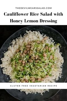 cauliflower rice salad with honey lemon dressing in a black bowl on a table