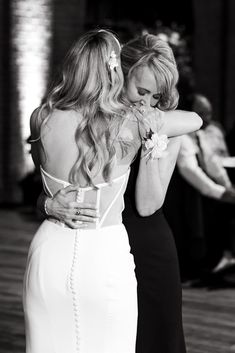 two women hugging each other at a wedding