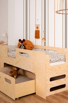 a child's bed with two drawers underneath it and a stuffed animal on the bottom bunk