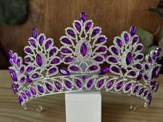 Beautiful, sparkles, good quality Tiara with big Grape Purple Rhinestone set on silver Tiara. Perfect for Prom, Birthday, Sweet 16, Quinceanera, Anniversary, Wedding, or for any other special occasion. Or just to be THE QUEEN. THE COLORS ON THE TIARA: Silver the tiara frame, Grape Purple and Crystal Rhinestone THE SIZE 3.5" tall on the front. 2.5" tall on the sides. GIFT BOX IT'S NOT INCLUDED! This item it will send on STANDARD FIRST CLASS MAIL (2 to 5 business days). in USA If you need sooner, Purple Tiara, Birthday Sweet 16, Quinceanera Tiaras, Tiara Silver, Prom Birthday, Birthday Tiara, Silver Tiara, Tiara Wedding, Purple And Silver