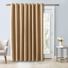 a living room with beige curtains and a chair