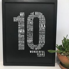 a black frame with the number ten written in different languages on it next to a succulent plant