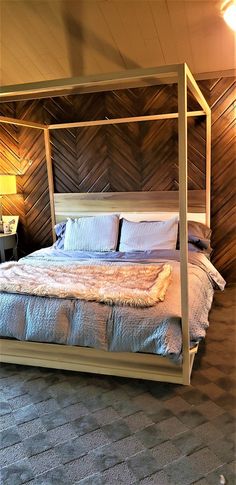 a bedroom with a four poster bed in the corner and wood paneling on the walls