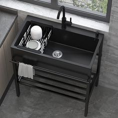 a black sink in a bathroom next to a window with white dishes and utensils