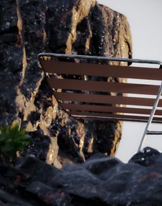 a metal chair sitting on top of a rocky hillside