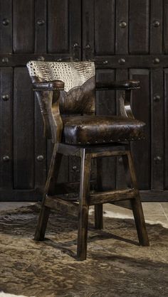 an old wooden chair with leather upholstered seat and arm rests on a rug