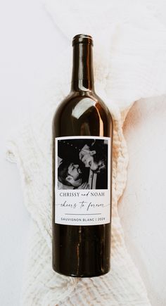 a bottle of wine sitting on top of a white blanket