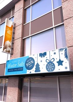 an advertisement for winter sale hanging from the side of a building in front of windows