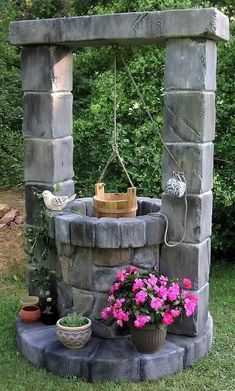 an outdoor fountain with potted plants and flowers