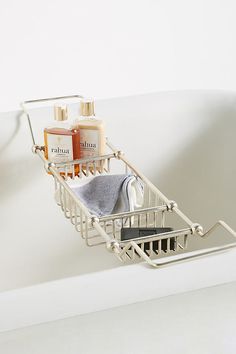 a bathroom sink with soap, shampoo and other items in the basket on it