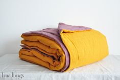 a yellow and purple blanket folded on top of each other