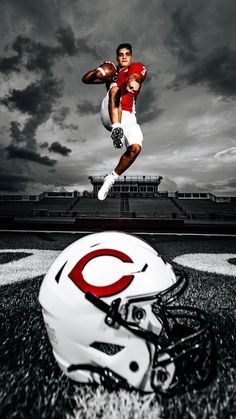 a football player jumping in the air with a helmet on the ground next to him