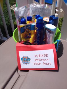 a basket filled with personal care products on top of a wooden table next to a sign that says please protect your paws