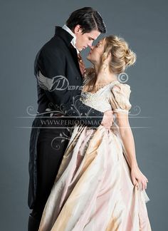 a man in a tuxedo kissing a woman in a ball gown on a gray background