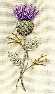 a close up of a flower on a piece of cloth with beads and needles in it