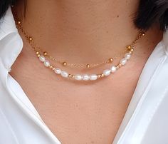 This double strand necklace is delicately made with high quality natural freshwater pearls. Ideal for bringing an elegant and chic style to all your outfits, it is perfect for a gift (wedding, birthday) for someone or for yourself (-: - Details - . Materials: - Gold stainless steel chain - Natural freshwater pearl 4×5mm . Necklace length 1st row satellite chain: 38cm 2nd row chain: 39cm +5cm adjustable chain. . The chain and the lobster clasp allow the necklace to be perfectly adjusted to the size of the neck (possibility of modifying the length of the necklace on request) . The necklace is sent (by registered letter) with an organza bag. If you mark the order as a gift, I will put the necklace in a gift bag closed with a sticker before posting it. . The stones used are natural, therefore Dainty Double Strand Pearl Necklace With Charm, Double Strand Pearl Necklace With Charm As Gift, Gift Double Strand Pearl Necklace With Charm, White Double Strand Pearl Layered Necklace, Elegant Double Strand Pearl Layered Necklace, White Pearl Double Strand Layered Necklace, Elegant Double Strand Pearl Necklace For Layering, Elegant Double Strand Layered Necklace With Pearl Charm, Delicate Double Strand Pearl Necklace