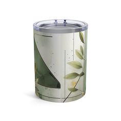 a white and green canister with leaves on the bottom, in front of a white background