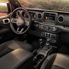 the interior of a jeep with black leather seats and steering wheel, dashboard, and dash board