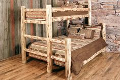 a rustic style bunk bed with pillows and blankets on it in a room that has wood flooring